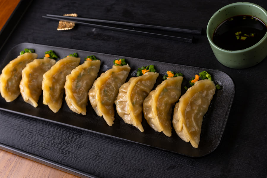 Assorted dumplings and gyoza on a black plate