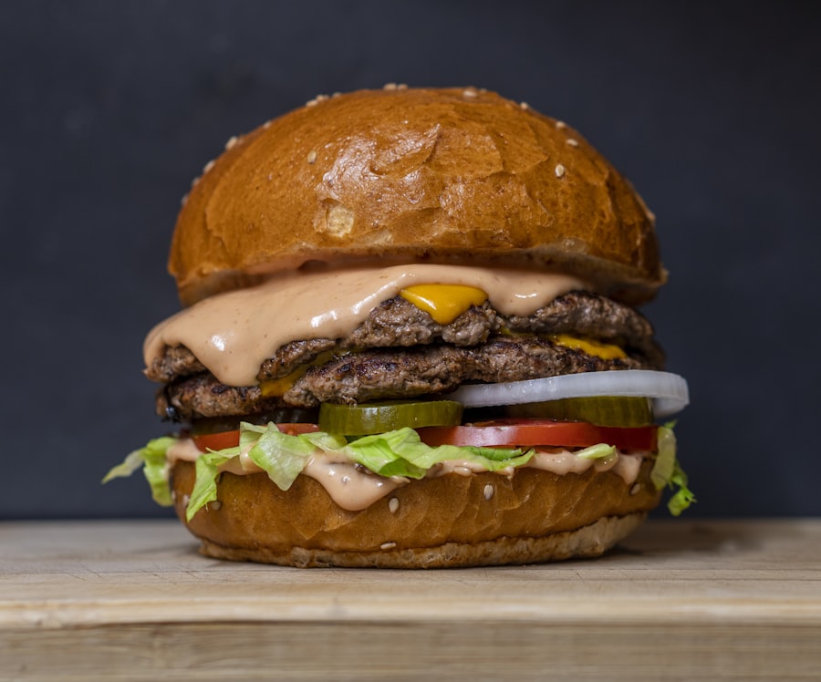 A stacked cheeseburger on a dark background